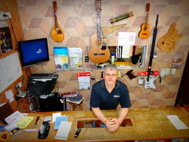 Luthier de instrumentos de cordas Murilo Ferreira, na recepção de sua oficina (Foto: Carlos Bozzo Junior)